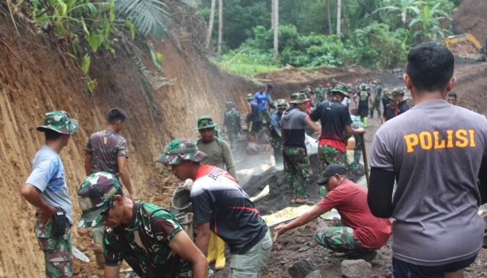 Meski Diguyur Hujan, Satgas TMMD Kodim Manado Bersama Masyarakat Terus Kebut Pembuatan Pengancing Jalan