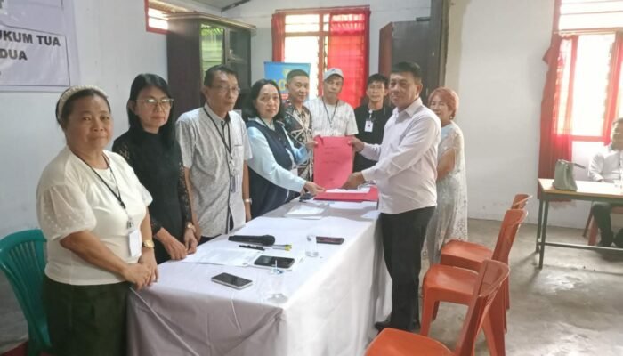 Ditemani Istri, Agustinus ‘ARUS’ Sinaulan Serahkan Formulir Pendaftaran Pilhut Pineleng Dua